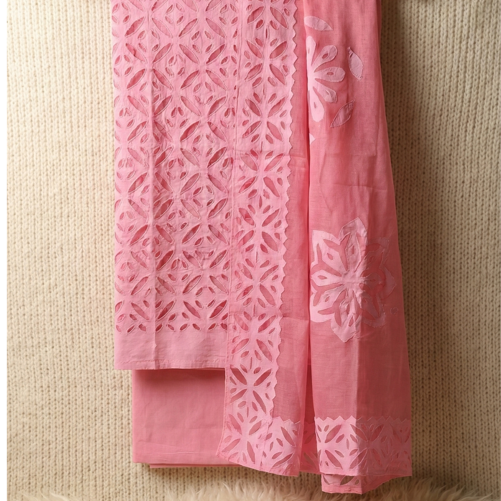 pink applique cutwork suit set material with geometric cutwork pattern on a light beige background
