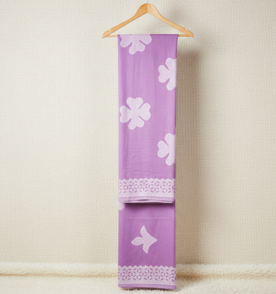 purple applique saree fabric on a hanger against a light background