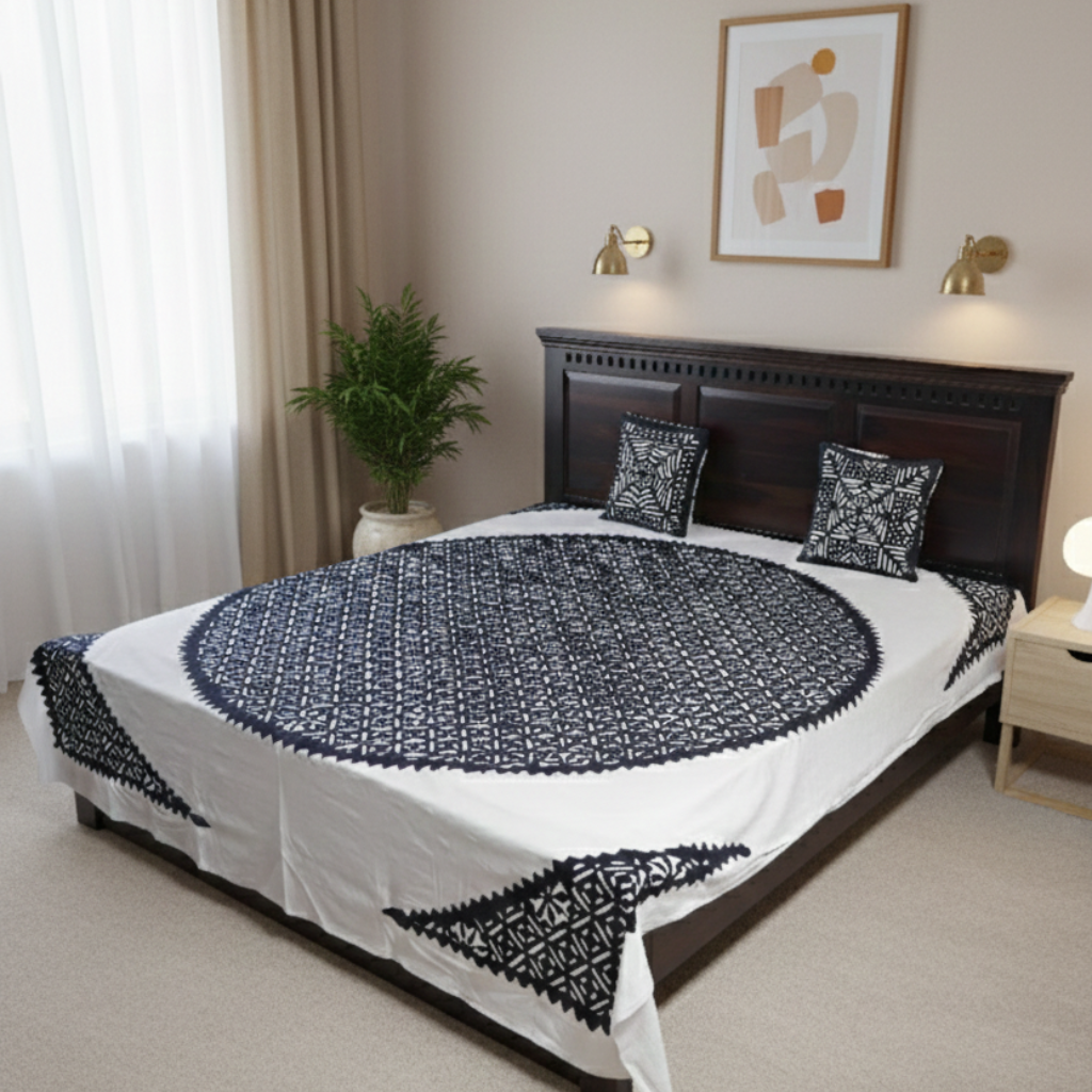 Bedroom with a bed covered in a white and blue patterned duvet, two pillows, and a plant on a windowsill.
