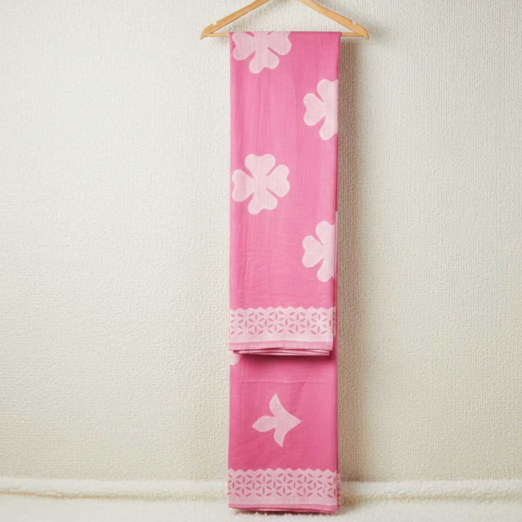pastel pink applique saree on a hanger against a light off white background