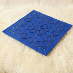 Blue decorative table linen with floral cutout pattern on a beige surface