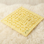 Yellow decorative mat with leaf pattern on a fluffy white surface