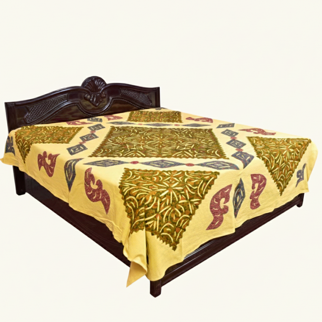 Decorative yellow applique bedspread with geometric pattern son a wooden bed